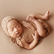 Handcrafted knitted newborn girl outfit, perfect for baby photography with lace details.